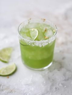 a green drink with limes and sugar on the rim