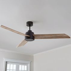 a ceiling fan in a room with white walls and wood trimmings on the ceiling