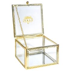 an open glass box with gold trimmings on the lid and bottom, sitting in front of a white background