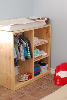 a wooden cabinet with clothes on it