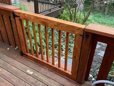 there is a wooden deck with railings on the outside and in the front yard