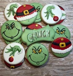 decorated christmas cookies with grin face and name on them, sitting on a wooden surface