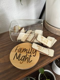 a wooden sign that says family night next to some potted plants on a table