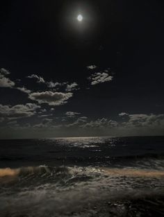 the moon is shining over the ocean with waves