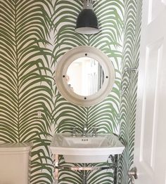 a white sink sitting under a mirror next to a toilet