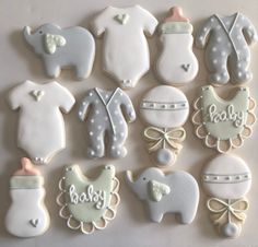 baby shower cookies arranged in the shape of animals and onesuits with names on them