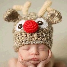 a baby wearing a crocheted reindeer hat