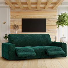 a living room with wood floors and a green couch in front of a flat screen tv