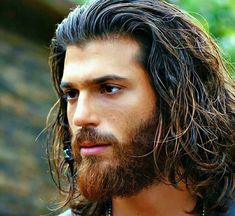 a close up of a man with long hair and beard