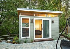 a small backyard shed with sliding glass doors and brick pavers walkway leading to the patio