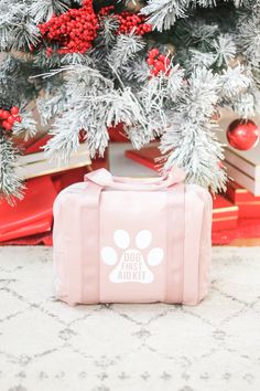 a pink bag sitting next to a christmas tree