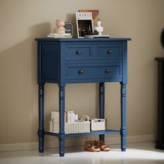 a blue table with two drawers and shoes on the bottom shelf in front of it