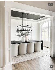 a dining room table with four chairs and a chandelier hanging from the ceiling