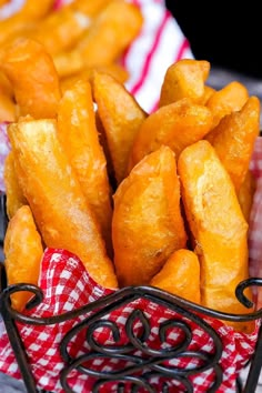 a basket filled with french fries sitting on top of a red and white checkered table cloth