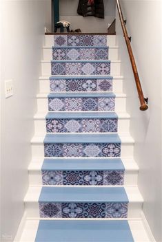 the stairs are painted with blue and white tile designs, along with a coat rack