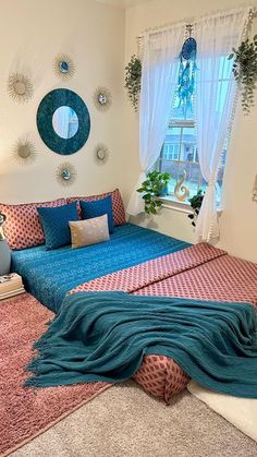 a bed room with a neatly made bed next to a window and potted plants