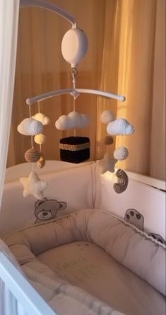 a baby crib with a teddy bear mobile hanging from it's side