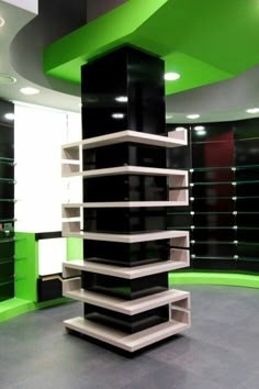 a tall black and white object in a room with green accents on the walls, along with shelving