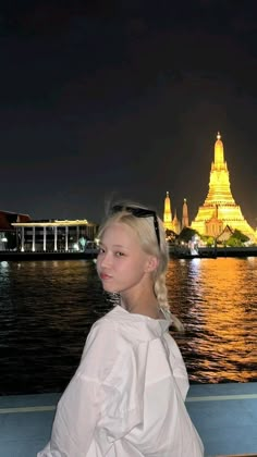 a woman sitting on the edge of a boat at night