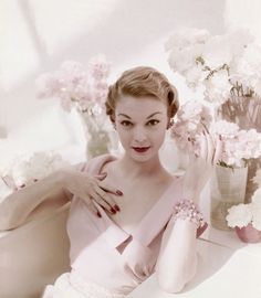 a woman sitting in front of a vase with flowers