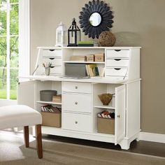 a white desk with drawers and a mirror on the wall above it in a living room