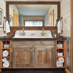 a bathroom with two sinks and wooden cabinets