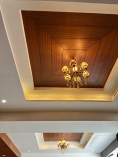 an empty room with chandeliers and wood paneling on the ceiling is seen in this image