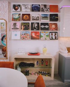 a living room filled with furniture and pictures on the wall next to a coffee table