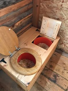 a wooden toilet with two bowls in it