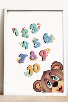 a poster with numbers and a teddy bear on it's face in front of a wall