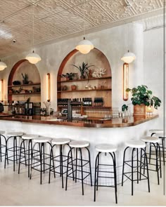 a bar with several stools and shelves filled with bottles