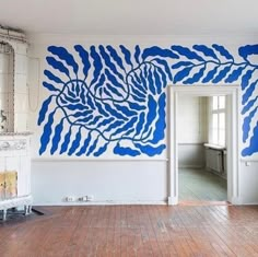 an empty room with blue paint on the walls and wood flooring in front of it