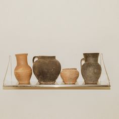 three vases are sitting on a glass shelf