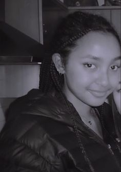 a woman with braids on her hair posing for a photo in a black and white photo