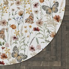 a close up of a flower and butterfly design on a white background with wood flooring