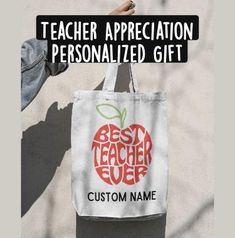 a person holding a bag with the words best teacher ever and an apple on it