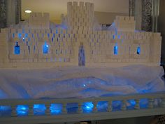 a castle made out of legos is shown in front of a mirror with blue lights