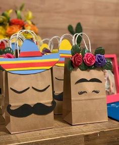 two paper bags with flowers and mustaches on them are sitting on a wooden table