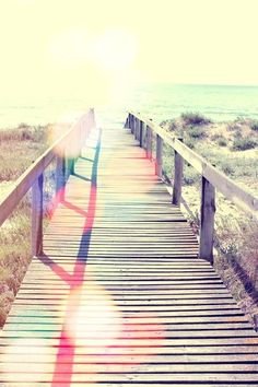 a wooden walkway leading to the beach with a quote above it that reads, she loved life and it loved her right back