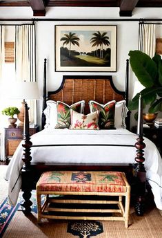 a bedroom with a canopy bed and palm trees on the wall above it is decorated in tropical colors