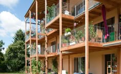 an apartment building with several balconies and plants