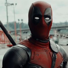 a deadpool is standing in the middle of a parking lot with his head turned to look like he's holding a baseball bat