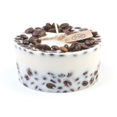 a white and brown cake with coffee beans on it's top, sitting in front of a white background