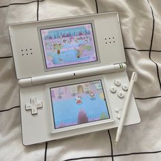 two nintendo wii games sitting on top of a bed next to a pen and paper