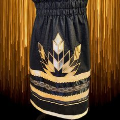 A Native American Ribbon Skirt made with Sparkling black and gold calico fabric with gold and black ribbons with gold rick rack. A feather applique design to the center of front of skirt. A two channel waistband and hidden pockets! Perfect for special occasions, Powwows, ceremonies and much more. Native American Ribbon Skirts Pattern, Native American Applique Designs, Black Ribbon Skirt, Ribbon Pants Native American, Ribbon Skirts Pattern, Native Ribbon Skirt, Ribbon Skirts Native American, Reworking Clothes, Metis Culture