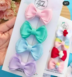 four different colored bows are shown in the package, and one is being held by someone's hand