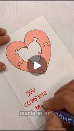 someone cutting out a valentine's day card with a crayon pencils