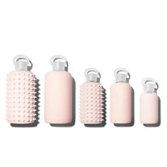 four pink bottles with handles are lined up in a row