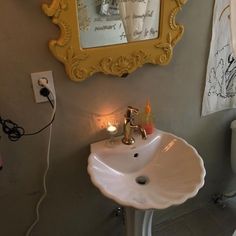 a bathroom with a sink, toilet and mirror on the wall next to a phone charger