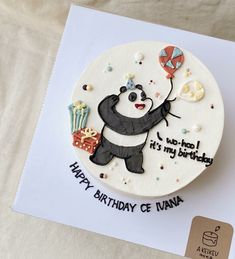 a birthday cake with a panda bear holding a balloon